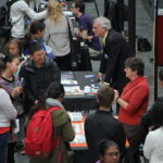 crowd of people at college fair tables